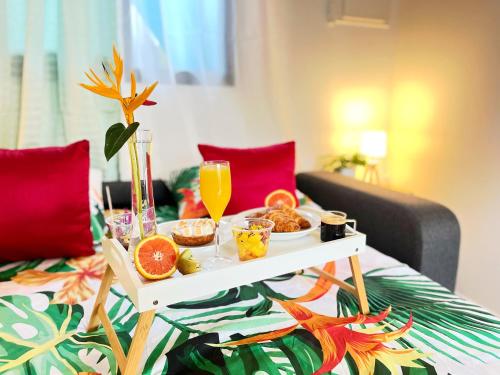 - une table avec un plateau de nourriture sur le lit dans l'établissement Cocon des jardins - Bungalow & SPA, à Gros-Morne