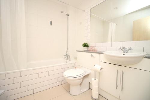 a white bathroom with a toilet and a sink at Centrally Located Spacious 2BR | CoHost Partners in Cardiff