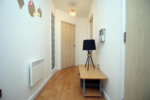 a hallway with a table with a lamp on it at Centrally Located Spacious 2BR | CoHost Partners in Cardiff