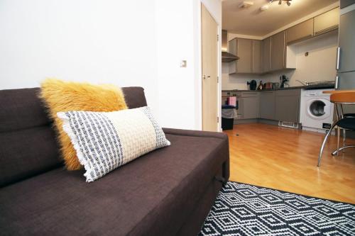 a couch with a pillow on it in a living room at Centrally Located Spacious 2BR | CoHost Partners in Cardiff