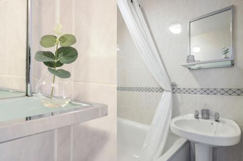 a bathroom with a sink and a vase with a plant in it at Chester Stays - Best Value Apartment with Free Parking in the heart of Chester in Chester