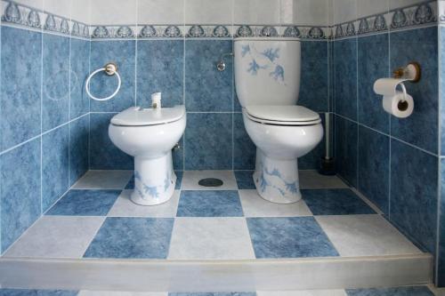 Baño de azulejos azules con aseo y lavamanos en Chalet con magníficas vistas al mar en Perlora