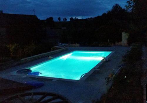 una piscina illuminata di notte di Résidence des Igues a Compolibat