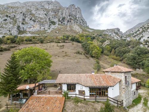 an old house with a mountain in the background at Albergue de Cabañes in Cabañes
