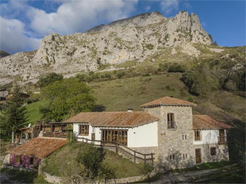 an old house in front of a mountain at Albergue de Cabañes in Cabañes