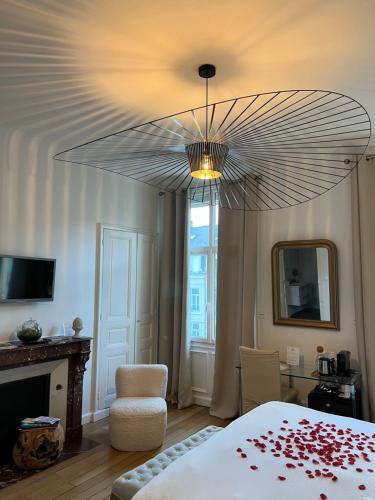 a bedroom with a bed and a chandelier at La Demeure des Sacres - Cathédrale in Reims