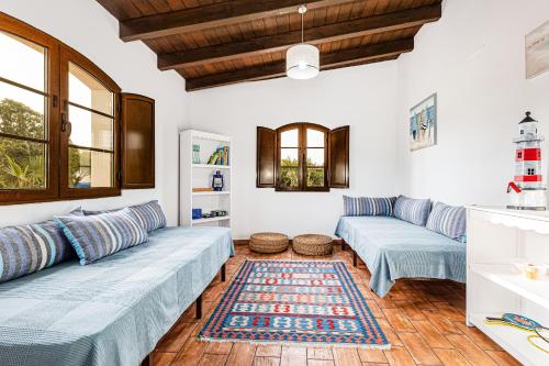 a living room with two blue couches and a rug at Villa Charme in Pêra