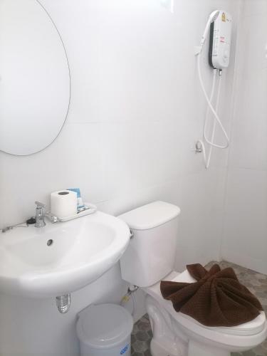 a bathroom with a sink and a toilet and a mirror at Baan KaemSai in Khao Lak