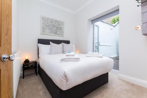 a bedroom with a large bed with a window at Vibrant 1BR Apt wPrivate Decked Garden, Fast WIFI in London