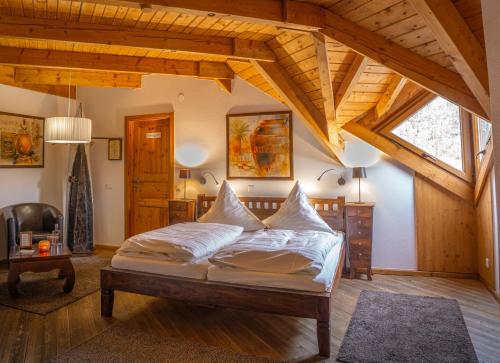 a bedroom with a bed in a room with wooden ceilings at Hotel-Restaurant Eifeler Seehütte in Rieden