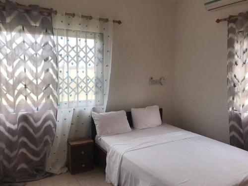 a bedroom with two beds and a window at Violettes Villa in Accra