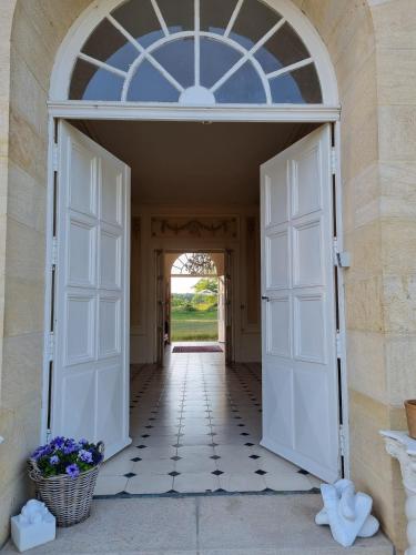 an open door into a hallway with flowers in a basket at Chateau Le Plessis in Sémelay