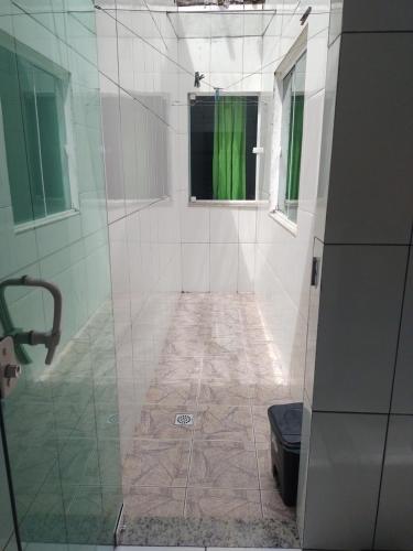 ein Bad mit einer Dusche und einem grünen Vorhang in der Unterkunft Casa Aconchegante in Cabo Frio