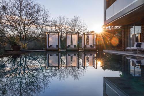a house with a swimming pool with the sun setting at Golfe Villa ' Paraíso de Luxo ' Piscina Aquecida in Ponte de Lima