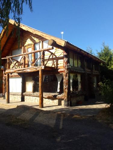 a log cabin with a gambrel roof at CABAÑAS EL PALENQUE in Esquel