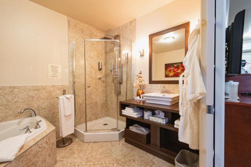 La salle de bains est pourvue d'une douche, d'une baignoire et d'un lavabo. dans l'établissement Auberge l'Ambassadeur, à Amqui