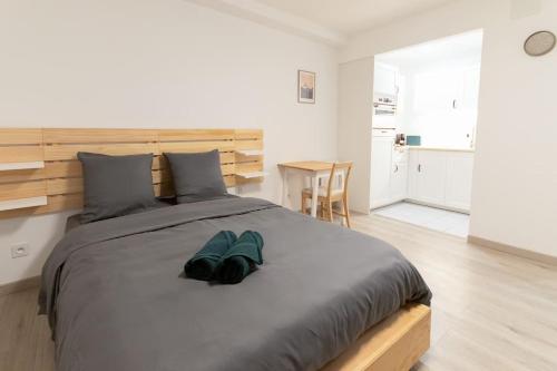 - une chambre dotée d'un grand lit avec des chaussures bleues dans l'établissement Le capucin, à Metz