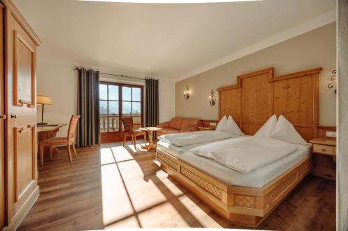 Schlafzimmer mit einem Bett, einem Schreibtisch und einem Tisch in der Unterkunft Hotel Lerch in St. Johann im Pongau