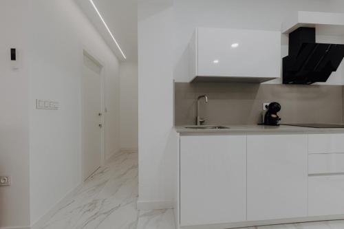 a kitchen with white cabinets and a sink at Excapada suite de Murcia in Murcia
