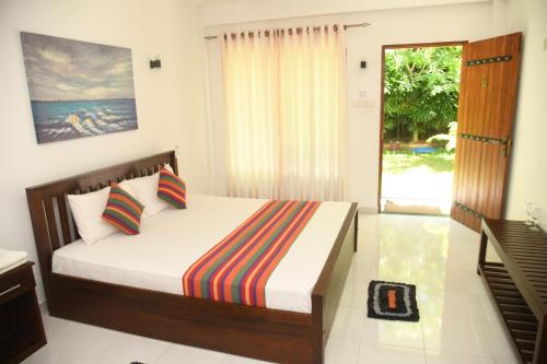 a bedroom with a bed and a sliding glass door at wild park safari home stay in Udawalawe