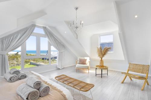 Habitación blanca con cama y vistas al océano en Sand Plover 85, en Grotto Bay