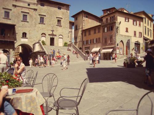 a group of people sitting at tables in a street at B&B San Francesco in Cortona