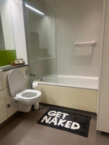 uma casa de banho com um WC, um chuveiro e um tapete. em LUXURY Leicester apartment em Leicester