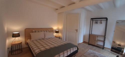 a small bedroom with a bed and two lamps at Einzigartiges Appartement im Höfli11 mit 3 Schlafzimmer in Solothurn