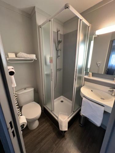 a bathroom with a shower and a toilet and a sink at initial by balladins Amiens / Longueau in Longueau