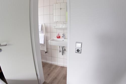 a bathroom with a sink and a mirror at Kaisergarten Hotel I Restaurant in Neuenrade