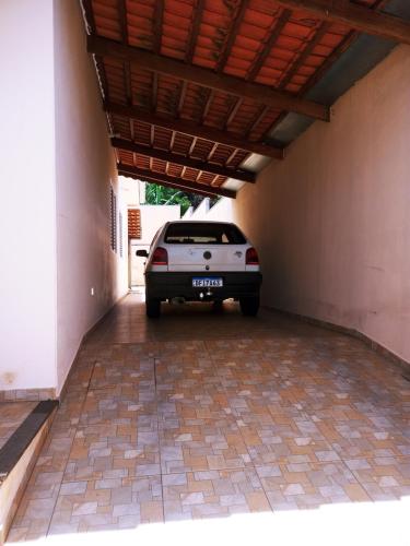 a car parked under a building with a roof at Casa da pri in São João Batista do Glória