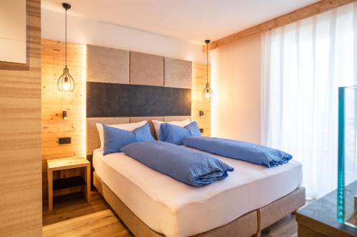 um quarto com uma cama com almofadas azuis em B&B al Borgo em San Lorenzo in Banale