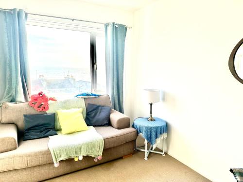 a living room with a couch and a window at The Captains Lookout-Sleeps 6! in St. Leonards