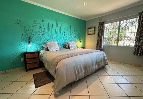 a bedroom with a large bed with a blue wall at Dragon & Eagle in Lydenburg