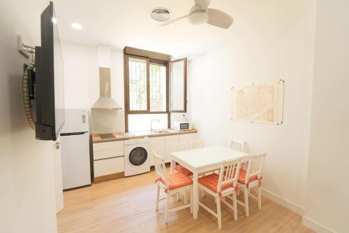 a kitchen with a white table and chairs in a room at Apartamento a estrenar en San Bernardo in Seville