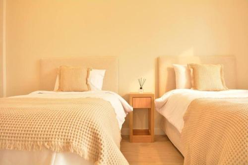 1 dormitorio con 2 camas con sábanas blancas y mesa en Hestia At Asuncin Luminous & Homely 2 Bdr Iv, en Asunción
