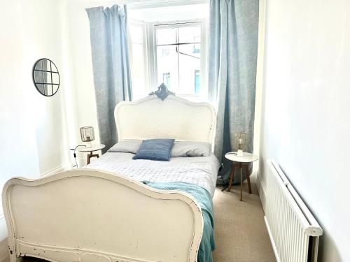 a white bed in a room with a window at The Captains Lookout-Sleeps 6! in St. Leonards