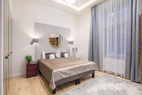 - une chambre avec un grand lit et un miroir dans l'établissement Central Market Residence, à Budapest