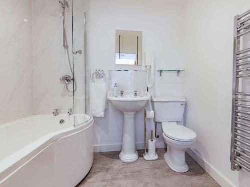 a white bathroom with a toilet and a sink at 4 Bed in High Bickington 86720 in High Bickington