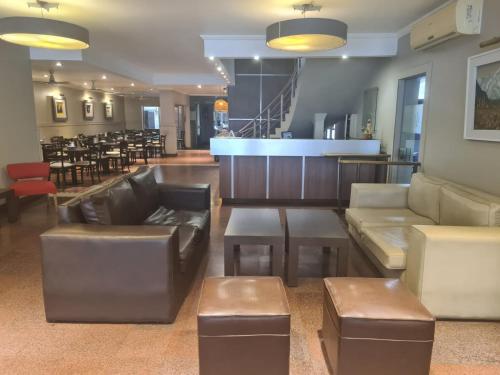 un vestíbulo con sofás y mesas y un bar en Libertador Hotel en La Rioja