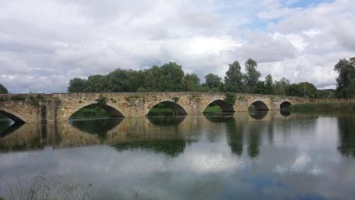 a stone bridge over a body of water at Villa La Nussa in Capolona