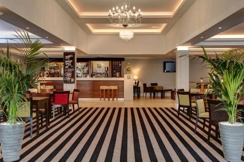 a restaurant with tables and chairs and a bar at Best Western Appleby Park Hotel in Tamworth
