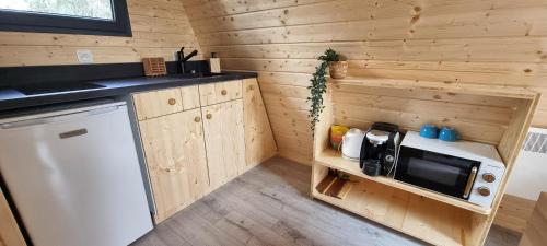 une petite cuisine avec un micro-ondes et un réfrigérateur dans l'établissement Le tipi Cathare hébergement insolite Carcassonne, à Alairac