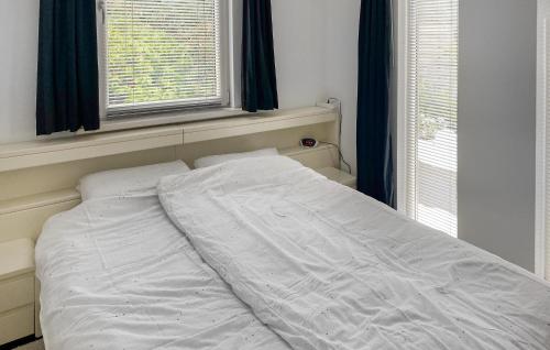 1 cama no hecha en un dormitorio con 2 ventanas en Cozy Home In Eext With Kitchen, en Eext