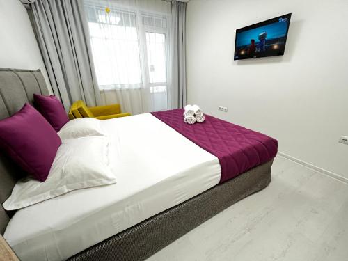 a bedroom with a bed with a teddy bear on it at Tevi Apartments in Varna City