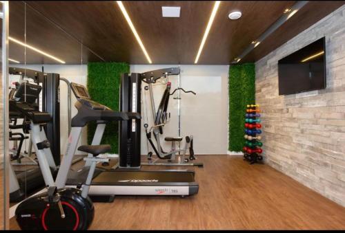 a room with a gym with a treadmill and a christmas tree at Apartamento Duplo Luxo com Jacuzi 6 lugares in Itajaí