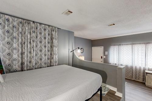 a bedroom with a white bed and a window at Okaloosa Island Studio in Fort Walton Beach