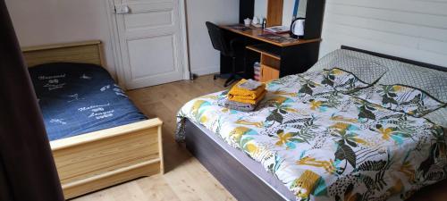 1 dormitorio con 1 cama con tocador y escritorio en Chambre chez l'habitant passiflore une, deux ou trois personnes, en Derval