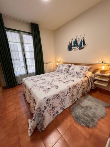 1 dormitorio con cama con colcha en CAMBARAL 1E, en Luarca