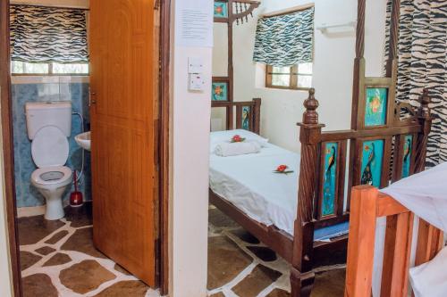 Tempat tidur dalam kamar di Kijani Cottages In Diani